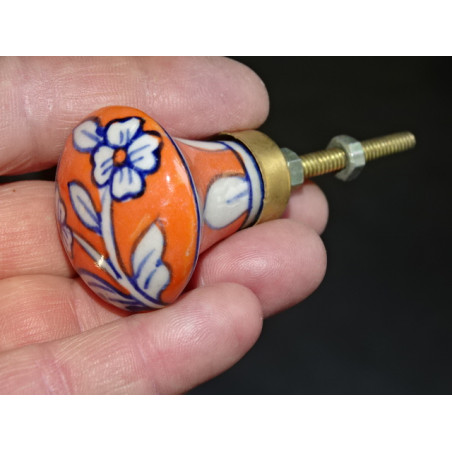 bouton en forme de poire orange avec deux fleurs bleues
