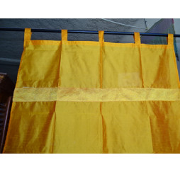 Bright orange taffeta curtains with a brocade band