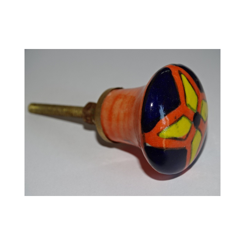 Botón naranja en forma de pera y flor amarilla y ultramar.